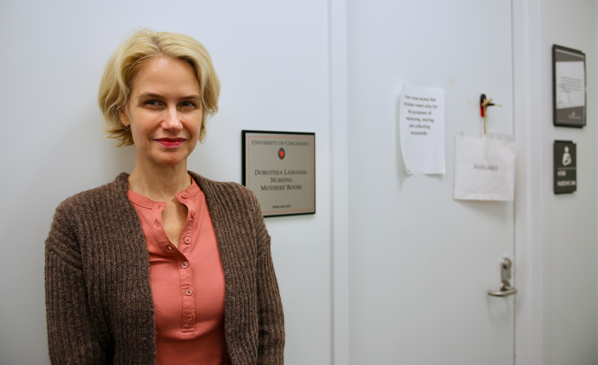 Thea Langsam in front of sign.