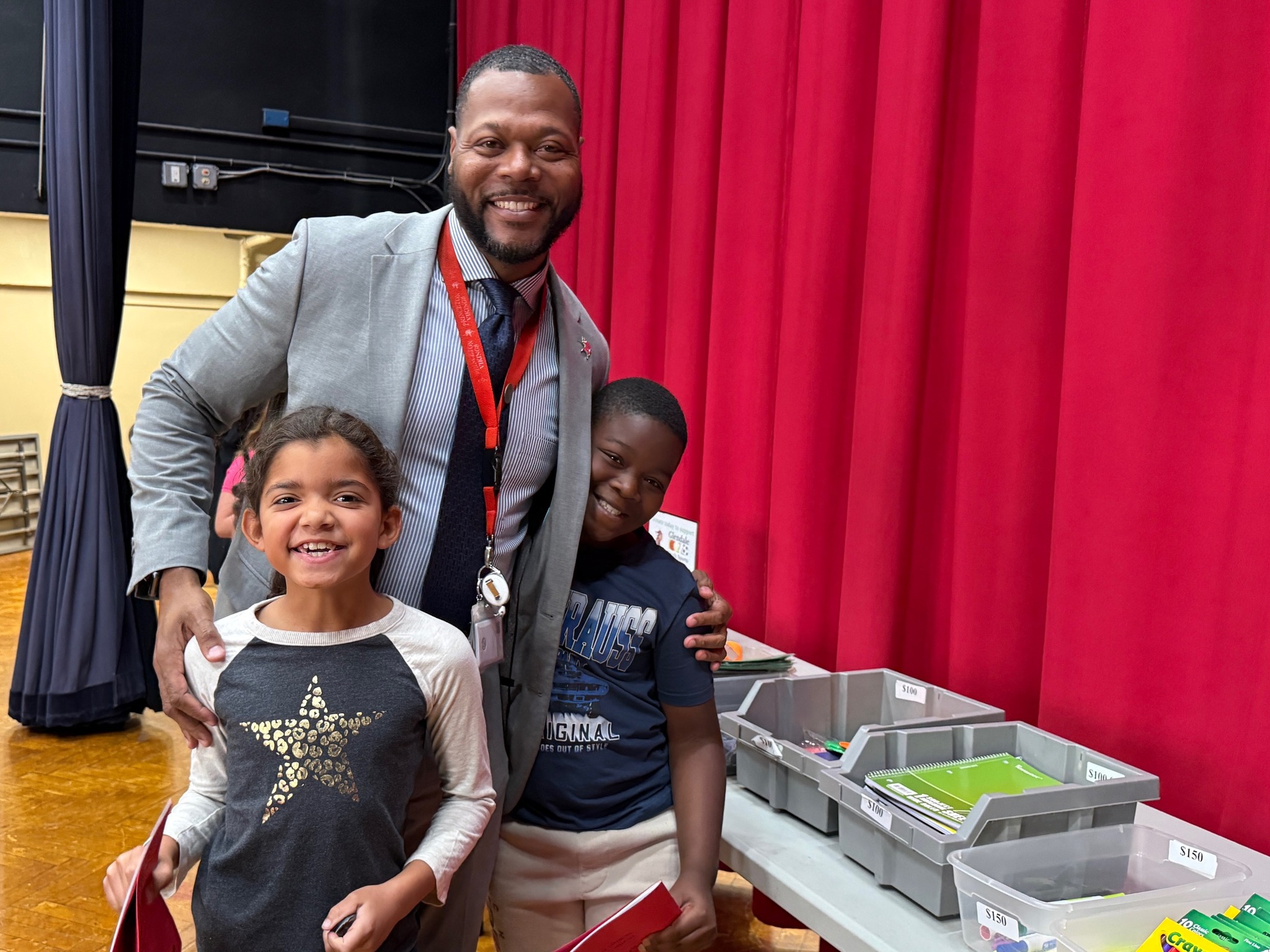Man in suit standing with two children.