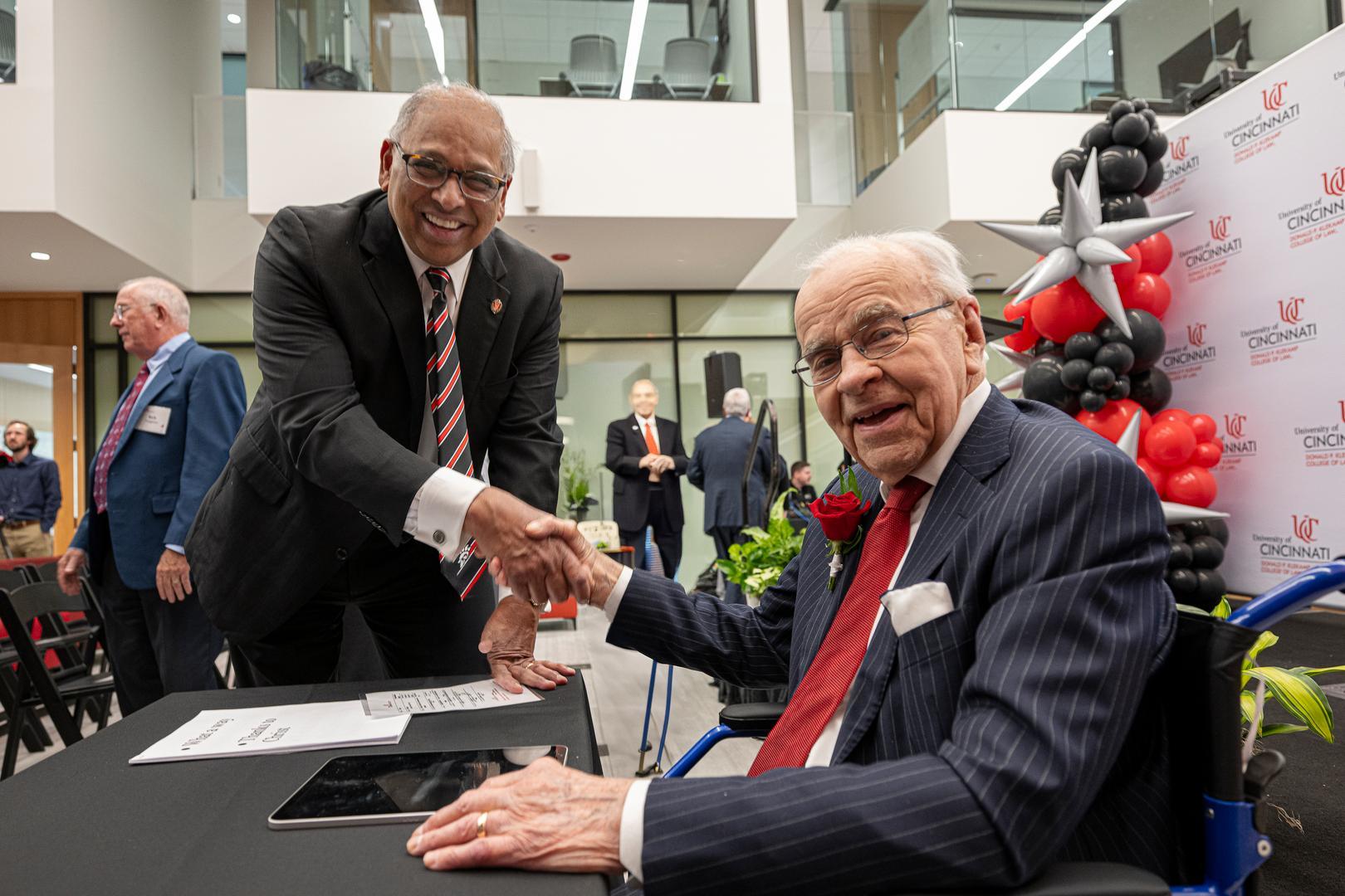 Neville Pinto and Donald Klekamp shaking hands and smiling.