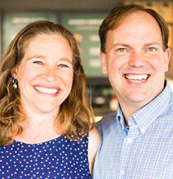 A man and a woman, smiling together as a couple.
