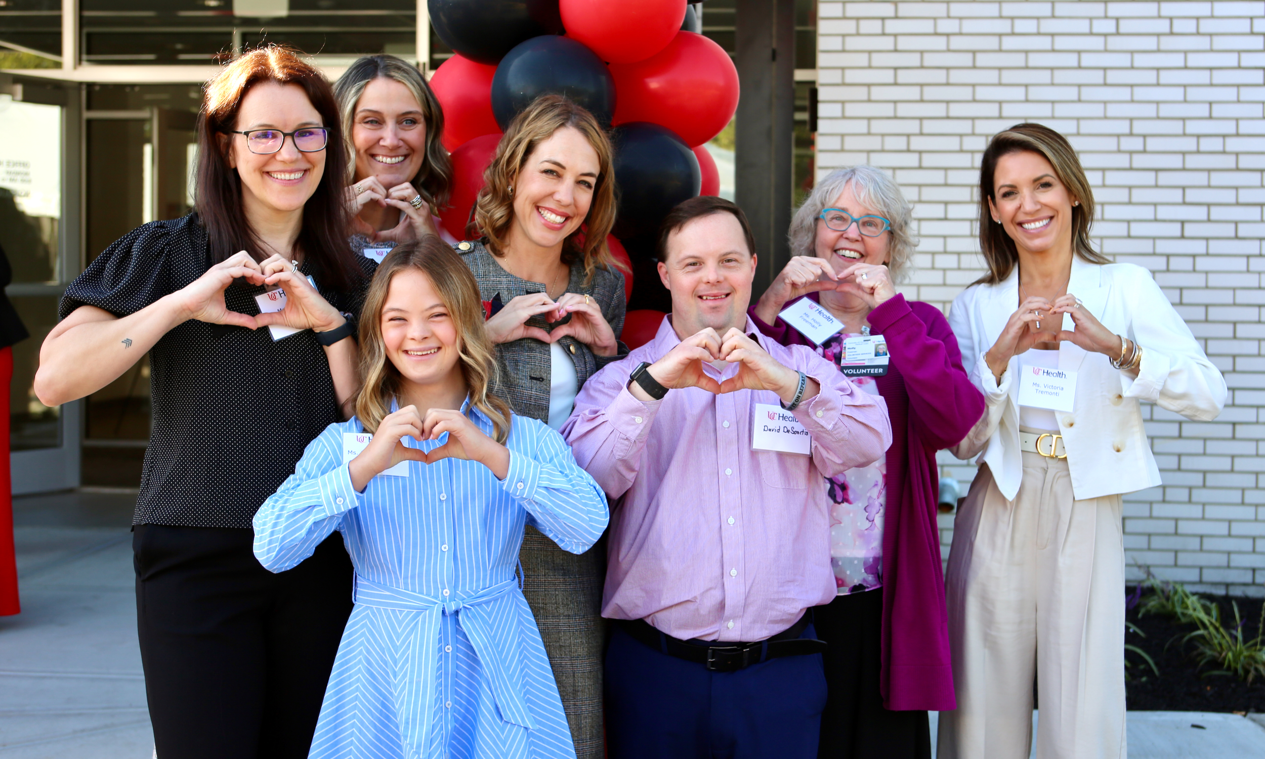 Group of people holding hands in a heart shape
