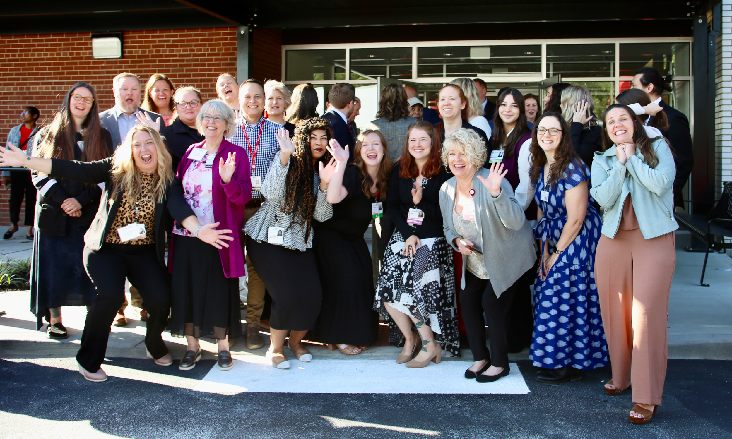 Group of people smiling and waving